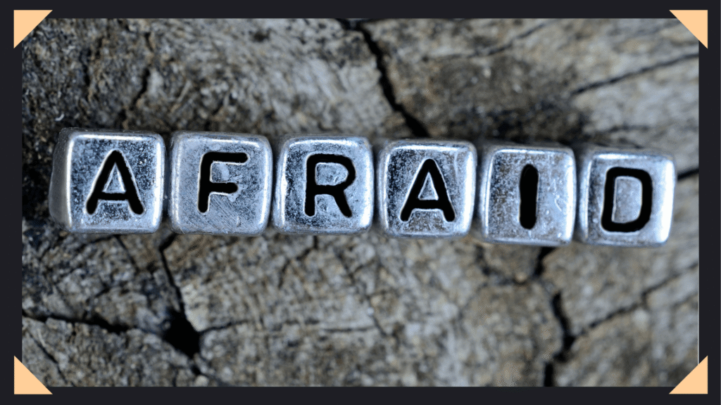 Concrete background with letter cubes spelling out the word "afraid"
