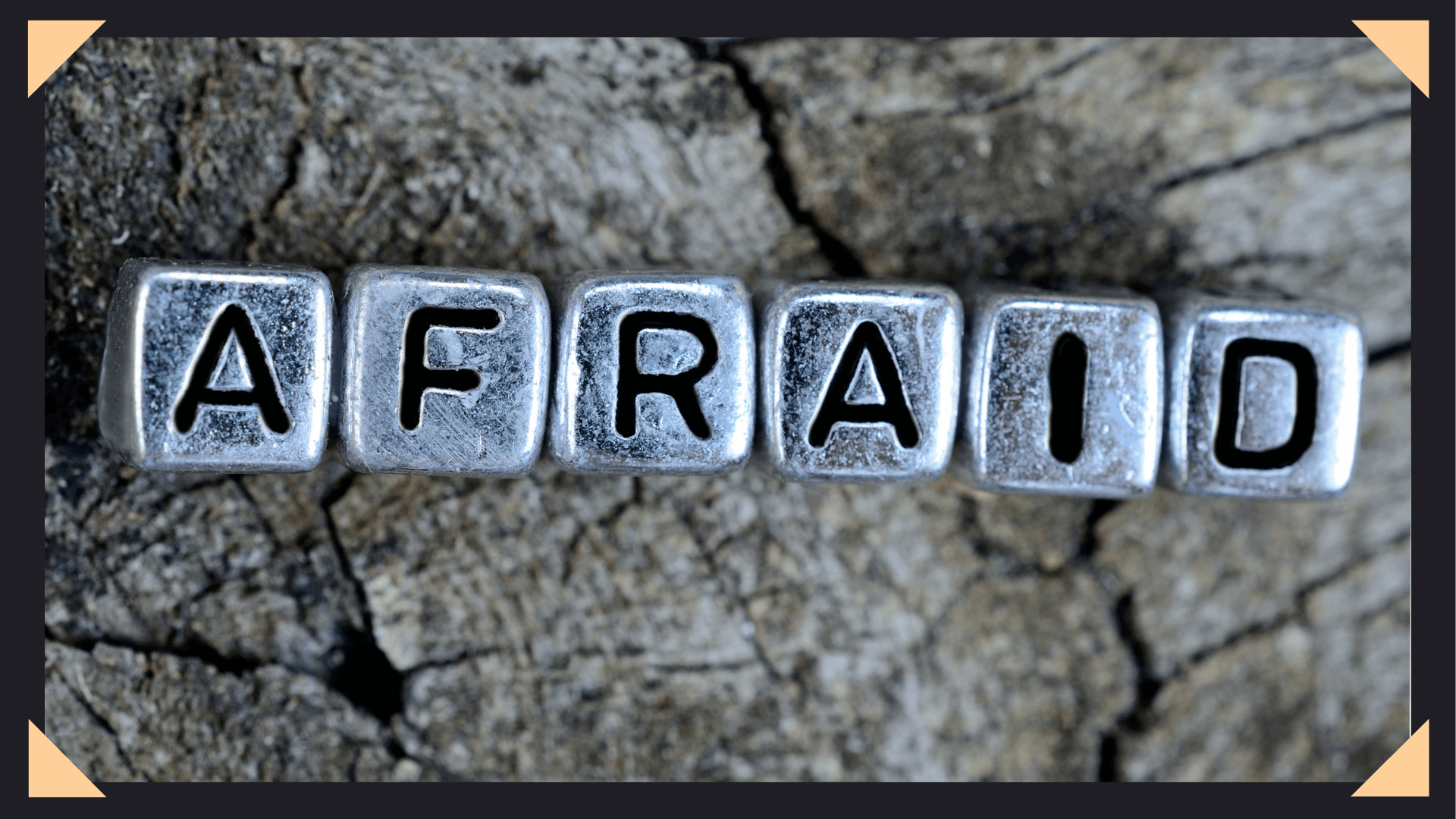 Concrete background with letter cubes spelling out the word "afraid"