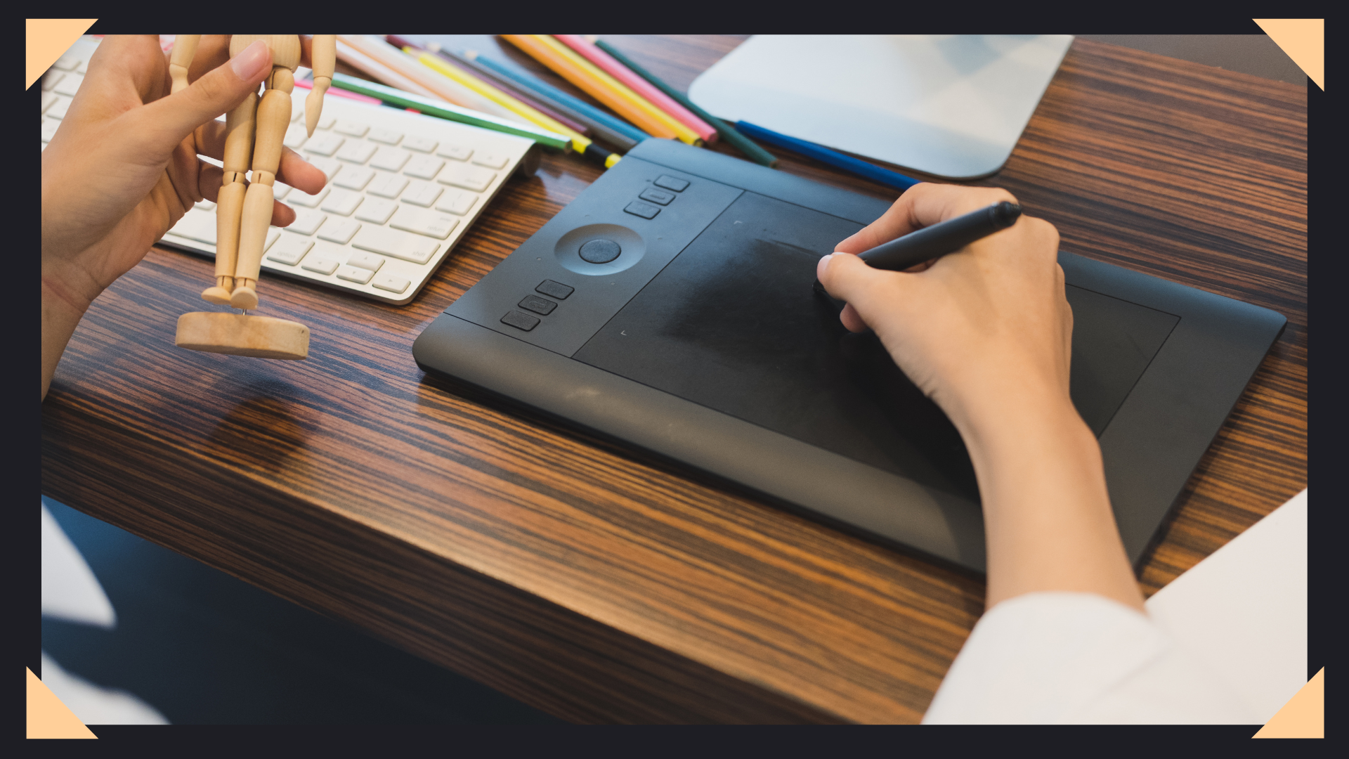 Image of an artist drawing on a graphics tablet with a keyboard