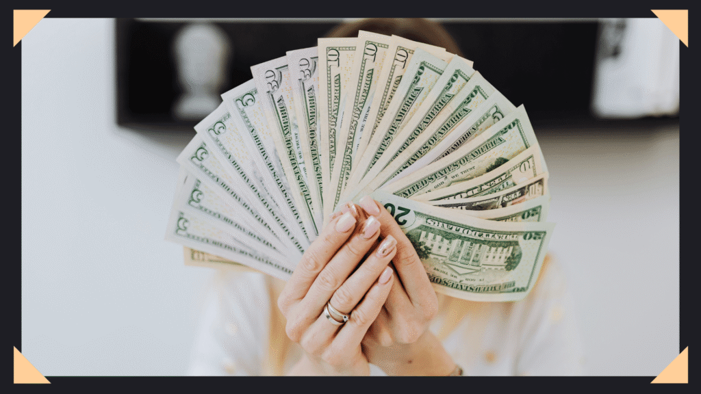 Woman holding up a fan of dollar bills