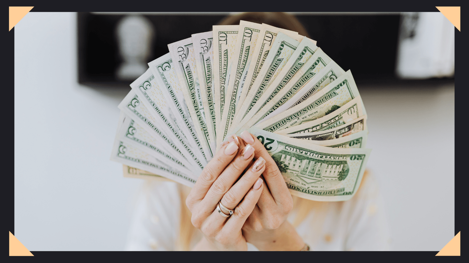 Woman holding up a fan of dollar bills