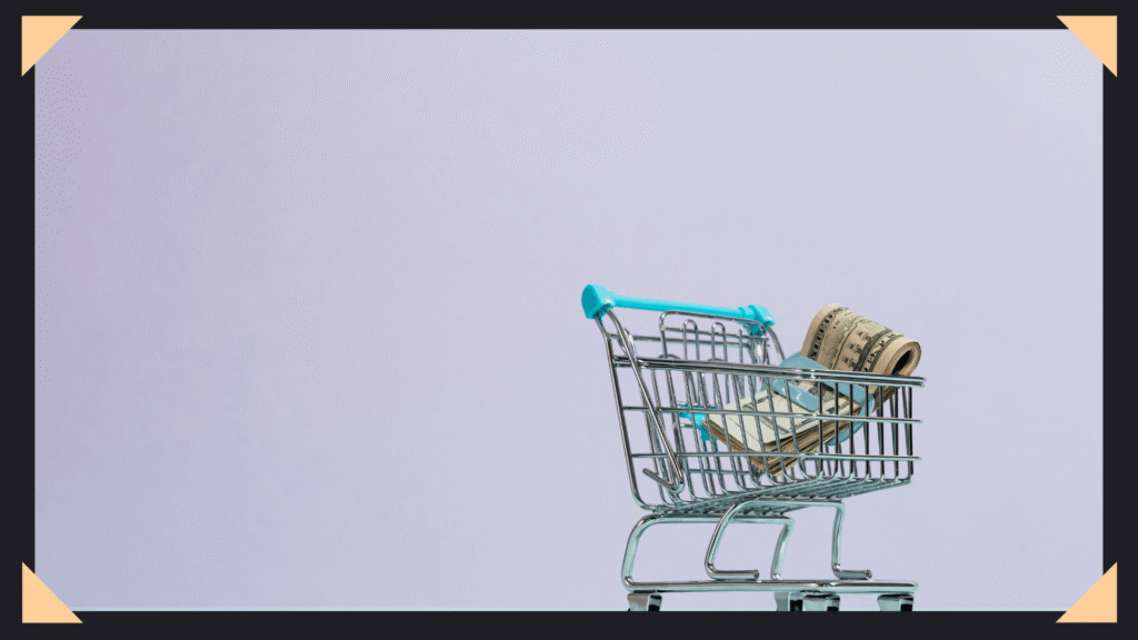 Image of small shopping cart with a small clip of cash in it